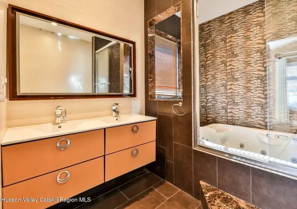 a bathroom with a tub sink and mirror