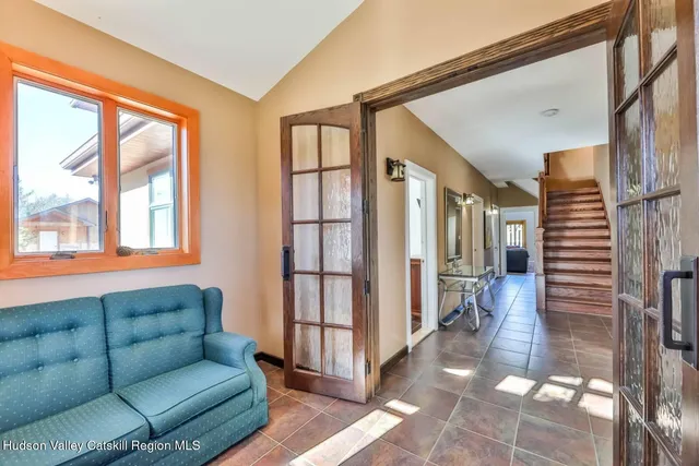 a living room with furniture a flat screen tv and a floor to ceiling window