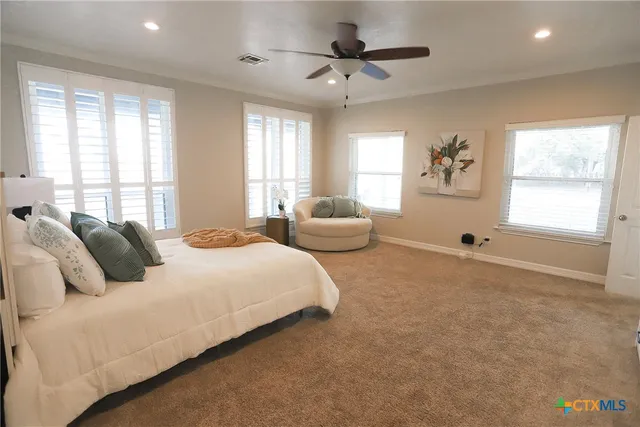 a spacious bedroom with a bed couch and window