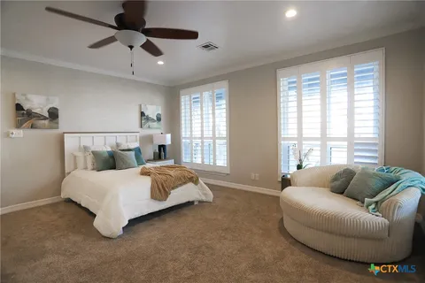 a spacious bedroom with a bed couch and window