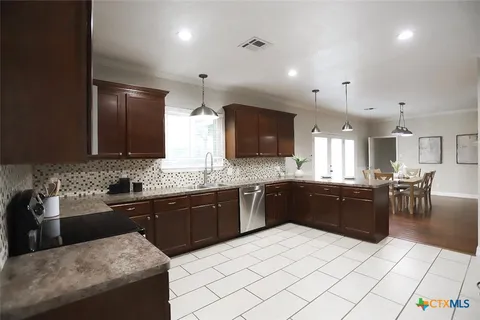a large kitchen with kitchen island granite countertop a sink counter space and stainless steel appliances