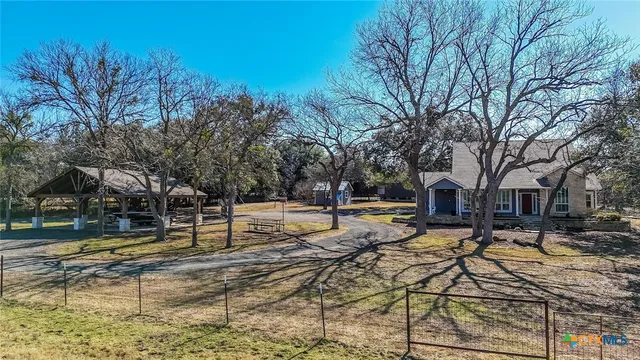 a view of a house with backyard and trees