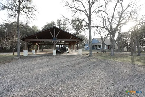 a view of a house with backyard and trees