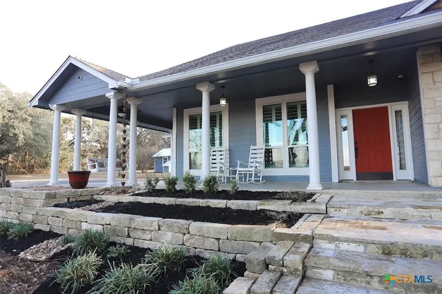a living room with furniture a fireplace and a chandelier