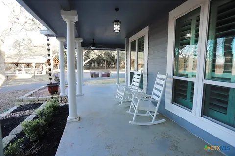 a porch with a table and chairs