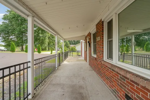 a view of a porch with wooden floor in front of house