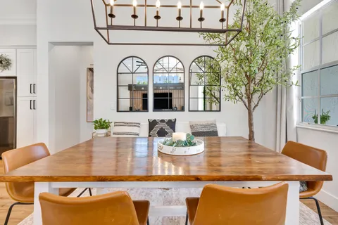 a living room with furniture kitchen view and a chandelier
