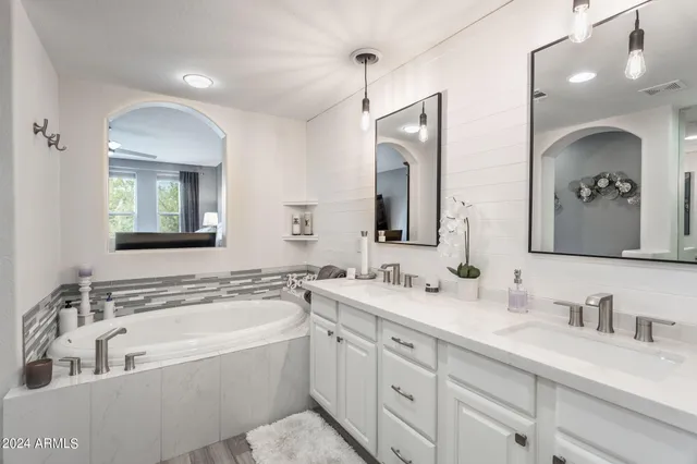 a bedroom with bed a lamp and a large window