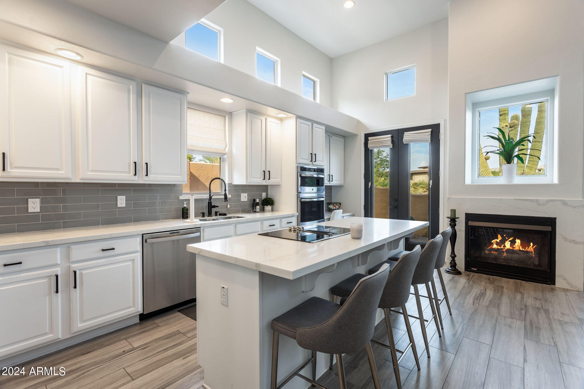 28990 North White Feather Lane, Unit 168 Scottsdale, AZ 85262 - Photo 6 of 36 a kitchen with a stove a sink dishwasher a dining table and chairs with wooden floor