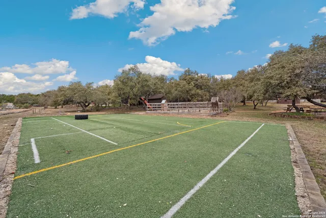 an aerial view of residential house with outdoor space and trees all around