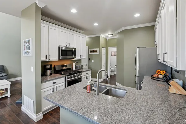 a kitchen with stainless steel appliances granite countertop a sink stove and refrigerator