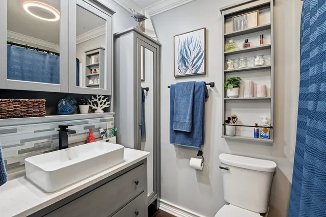 a bathroom with a sink a toilet and shower