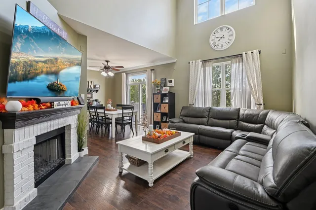 a living room with furniture a fireplace and a large window
