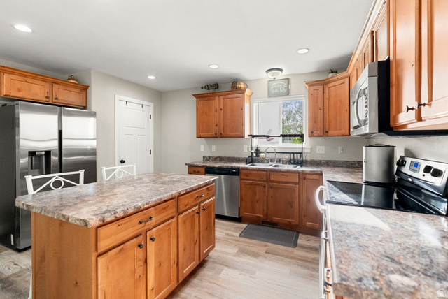 2485 South 1100th Street West Logan, UT 84321 - Photo 18 of 53 Kitchen featuring a central island, wood-finish cabinetry, stainless steel appliances, and wood-finish flooring