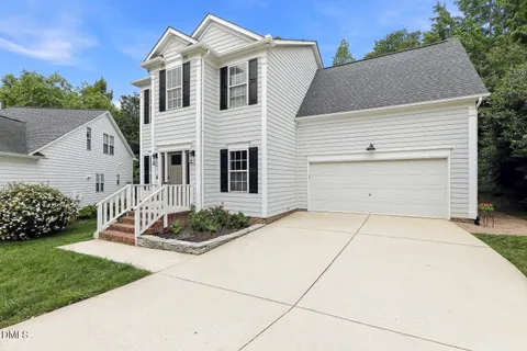 a view of a white house with a yard and garage