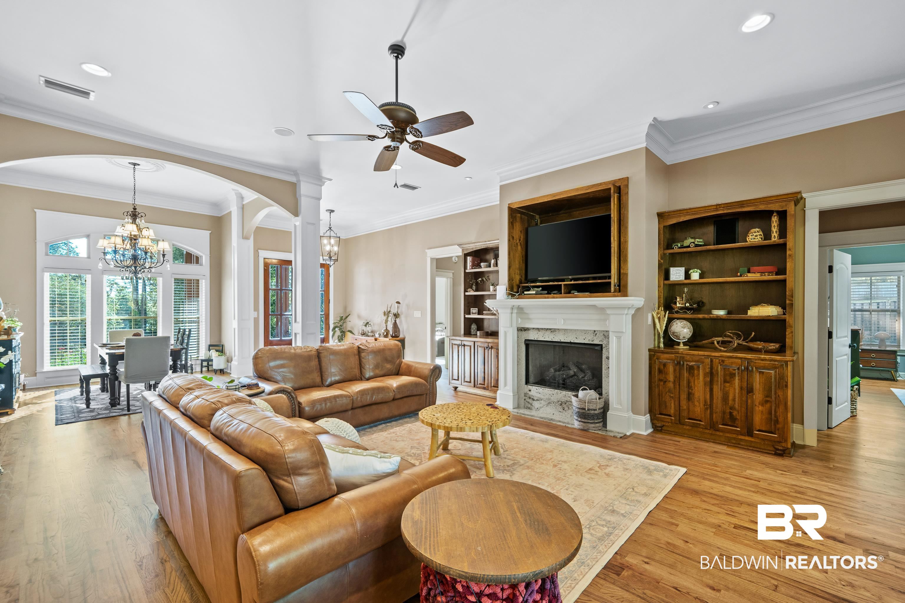 31829 Butler Drive Daphne, AL 36527 - Photo 9 of 48 Living room featuring ceiling fan with notable chandelier, a premium fireplace, light hardwood / wood-style floors, and a healthy amount of sunlight