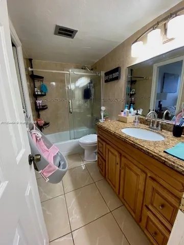 a spacious bathroom with a granite countertop sink a mirror and shower