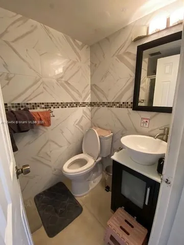 a bathroom with a sink toilet and mirror