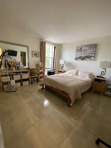 a bedroom with a bed couch and a window