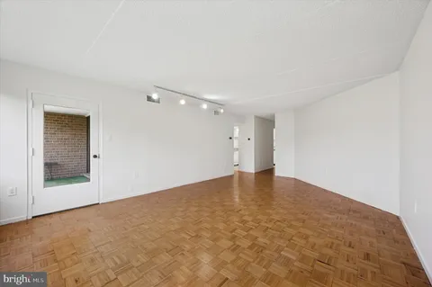 a view of empty room with wooden floor