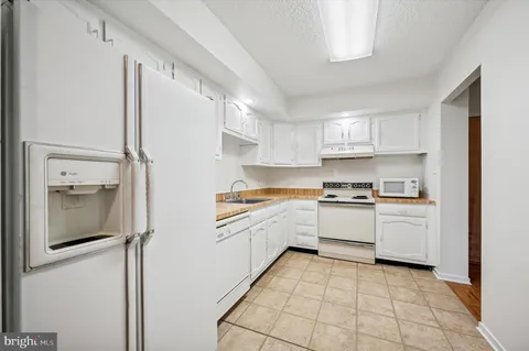 a kitchen with granite countertop a sink stove and refrigerator
