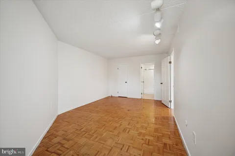 a living room with furniture a refrigerator and a potted plant