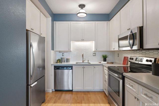 a kitchen with stainless steel appliances a refrigerator sink and microwave