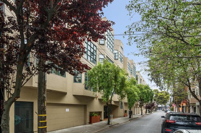 a front view of a building with a tree