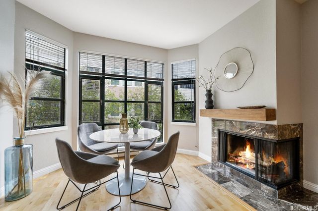 a dining room with furniture a fireplace and wooden floor