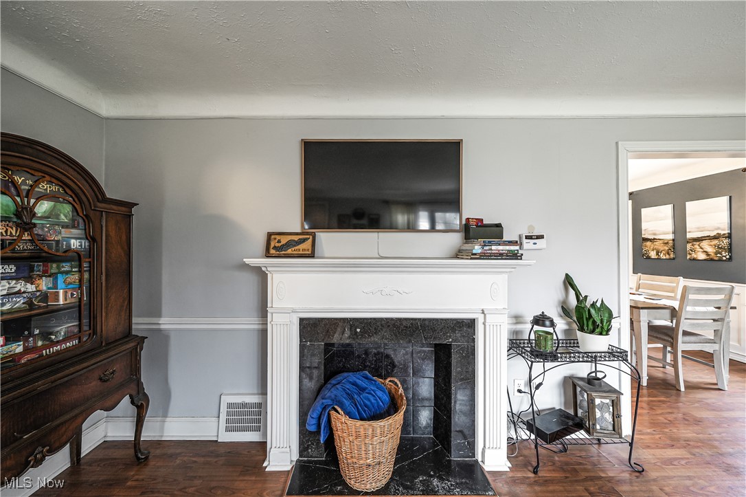 4819 Westbourne Road Cleveland, OH 44124 - Photo 32 of 39 Living area featuring a textured ceiling, a fireplace, visible vents, and wood finished floors
