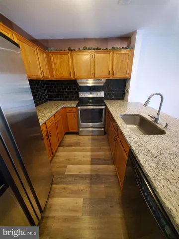 a kitchen with kitchen island granite countertop a sink and a stove
