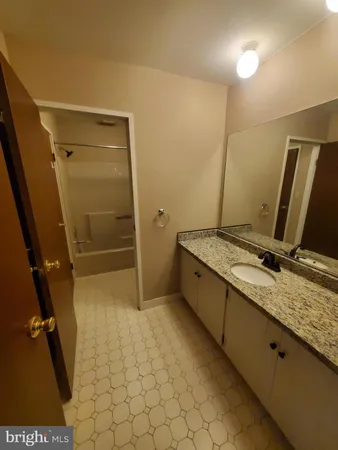 a bathroom with a granite countertop sink a toilet and a shower