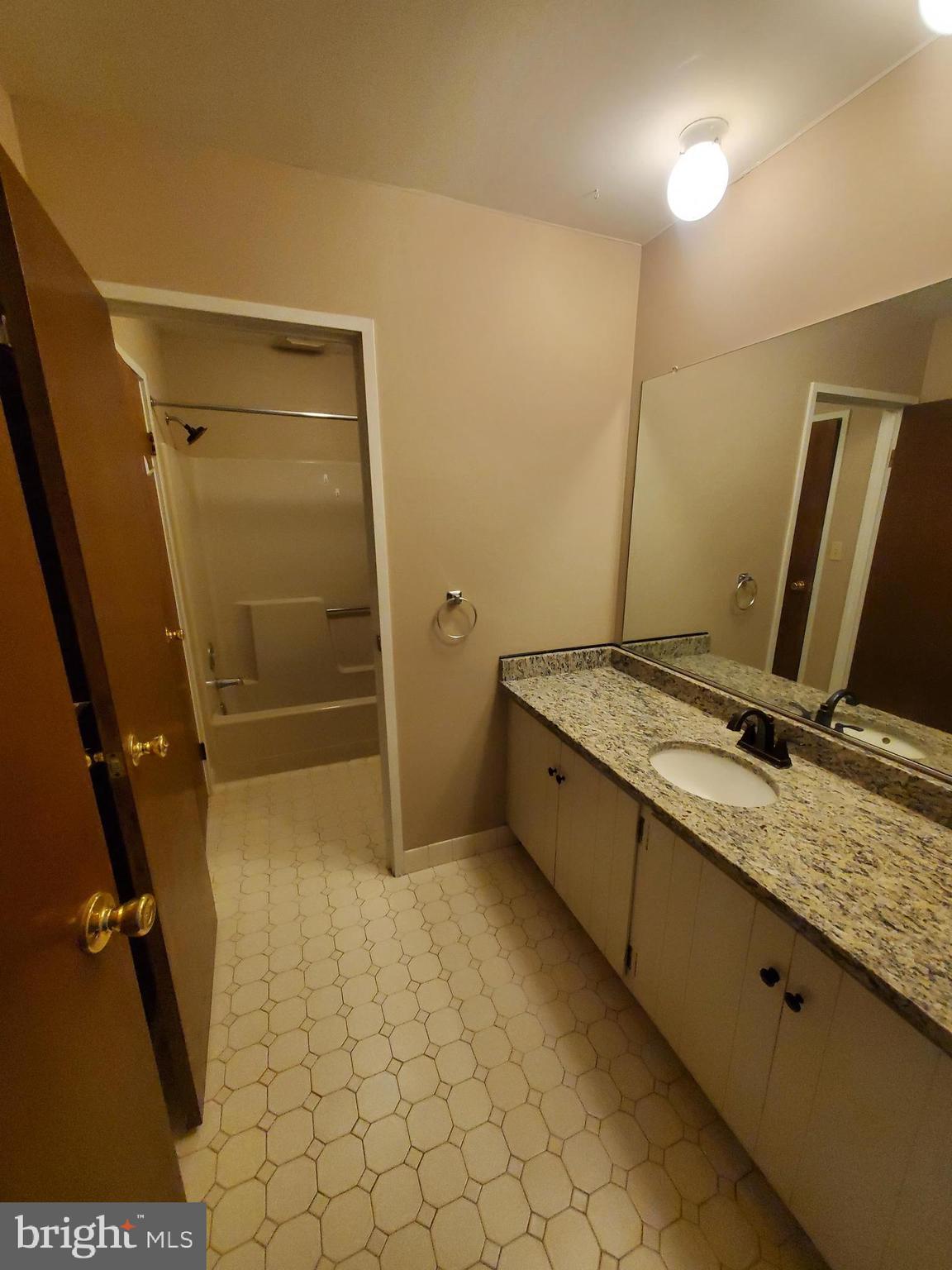 48 C Muirfield Drive Reading, PA 19607 - Photo 8 of 15 a bathroom with a granite countertop sink a toilet and a shower
