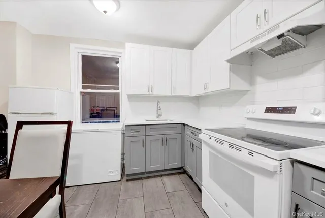 a kitchen with white cabinets and white appliances