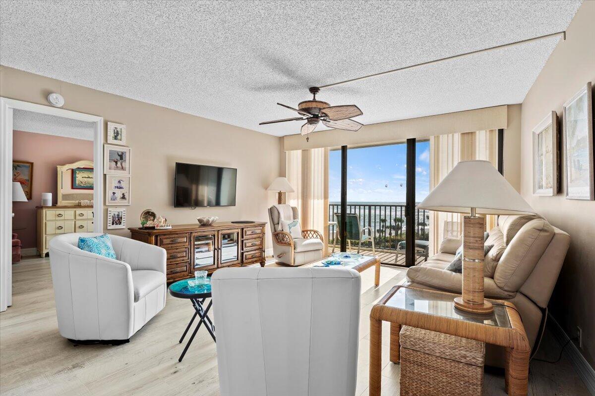 400 Ocean Trail Way, Unit 504 Jupiter, FL 33477 - Photo 4 of 27 a living room with furniture a flat screen tv and a large window