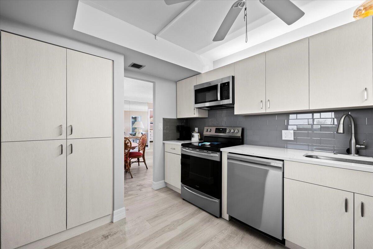 400 Ocean Trail Way, Unit 504 Jupiter, FL 33477 - Photo 6 of 27 a kitchen with a sink cabinets and stainless steel appliances