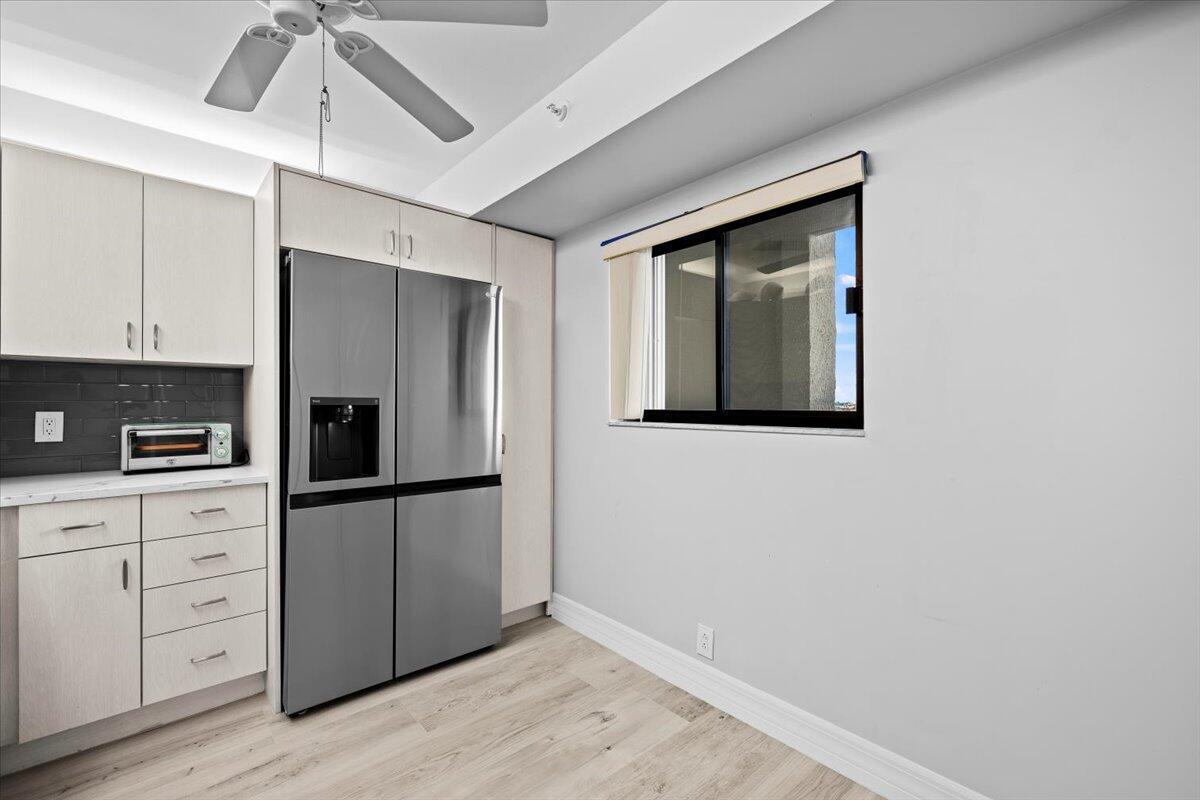 400 Ocean Trail Way, Unit 504 Jupiter, FL 33477 - Photo 8 of 27 a kitchen with white cabinets and refrigerator