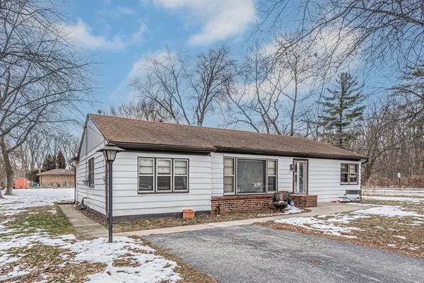 a view of a house with a yard covered in snow