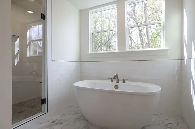 a white bath tub sitting next to a shower