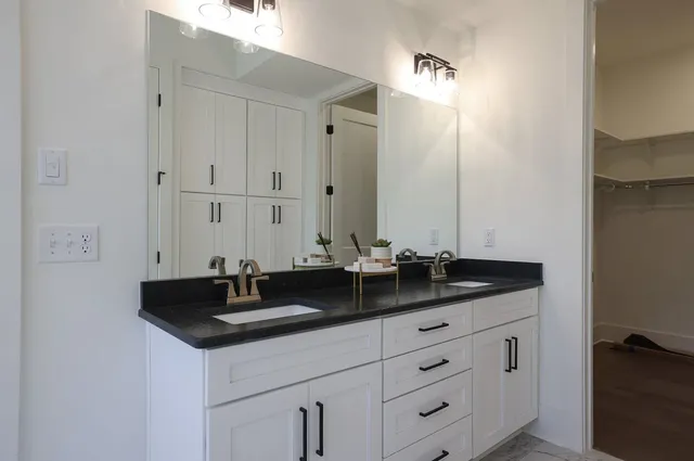 a bathroom with double sink and a mirror