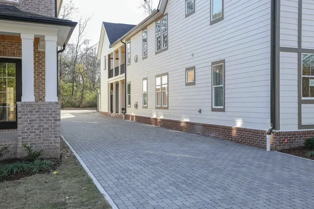 a view of a house with backyard and parking area