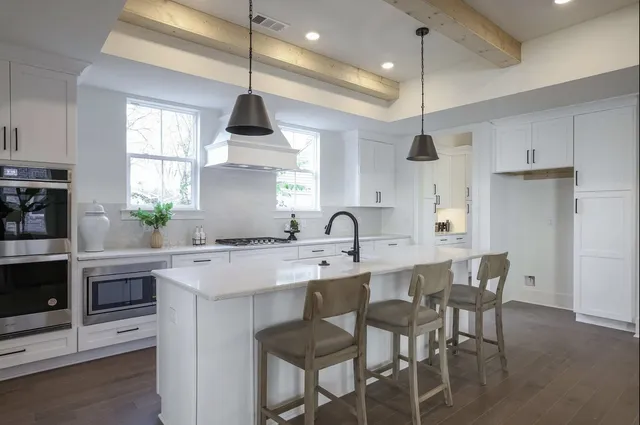a kitchen with stainless steel appliances a kitchen island a stove a table and chairs in it