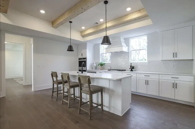 a kitchen with appliances a sink a table and chairs in it