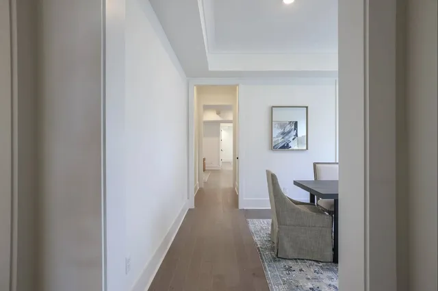 a view of a hallway with wooden floor and a livingroom