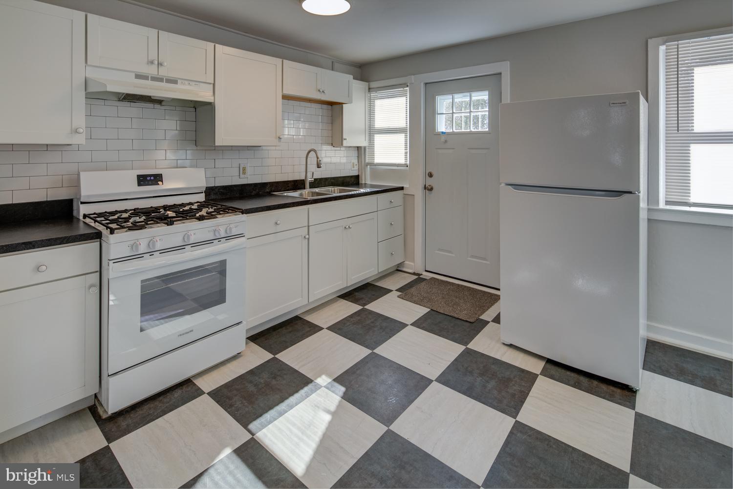 36 Thompson Circle Newark, DE 19711 - Photo 19 of 22 a kitchen with a checkered floor and white cabinets