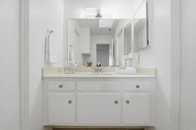 a bathroom with double vanity sink and a mirror