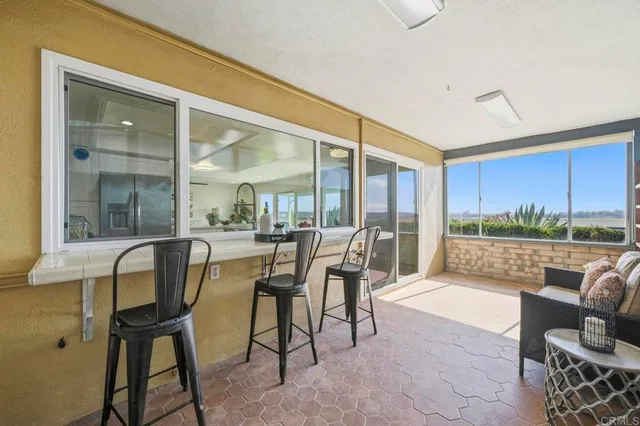 a dining room with furniture and a floor to ceiling window
