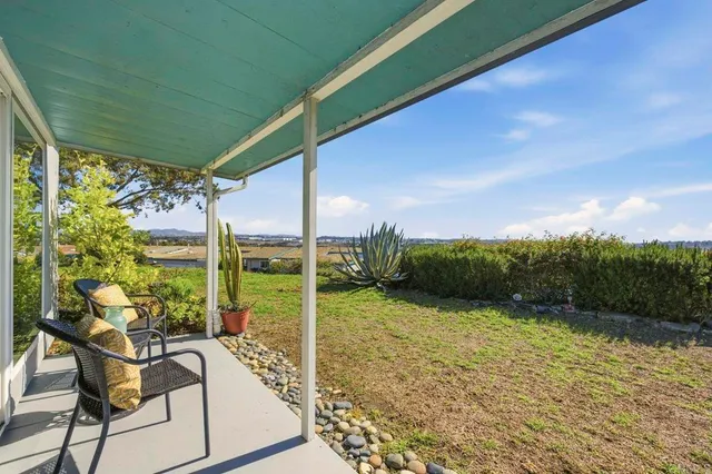 a view of a patio with a table chairs and a backyard