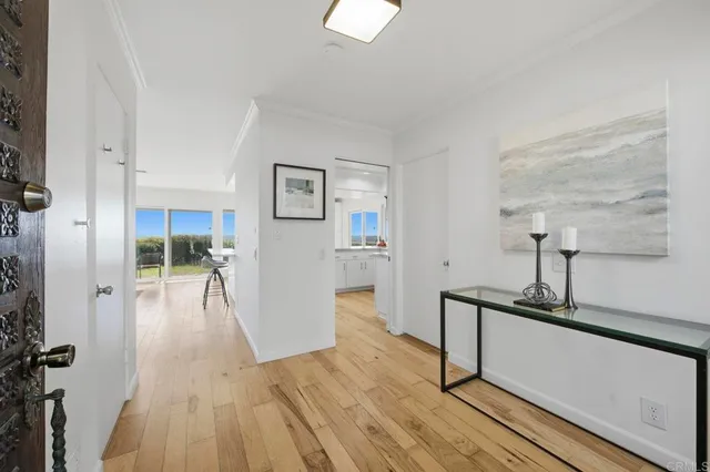 a hallway with wooden floor table and chairs