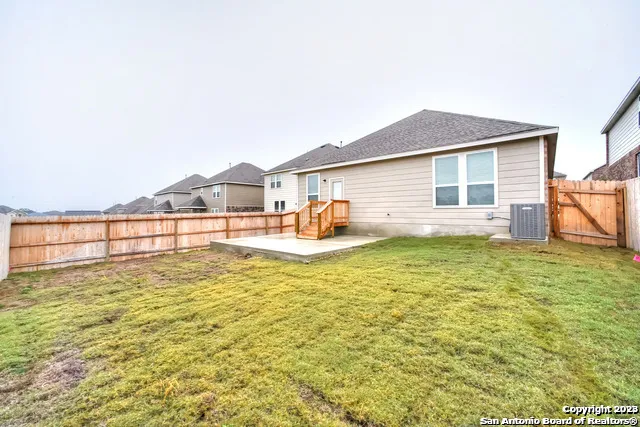 a view of a house with a backyard and a patio